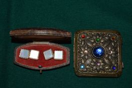 A pair of cufflinks and a compact.