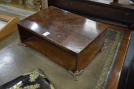 A burr wood open storage compartment with ormolu feet.