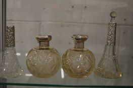 Four silver mounted cut glass perfume bottles.