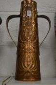 An Arts and Crafts embossed copper twin handled vase.