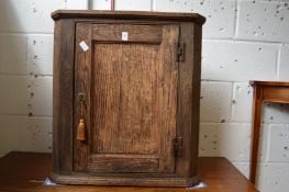An oak hanging corner cupboard.
