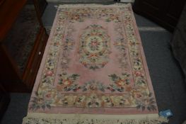 A Chinese pink ground rug, 190cm x 122cm.