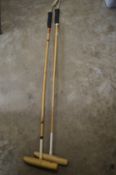 Two polo mallets.