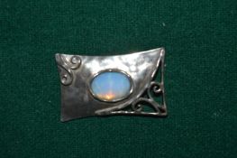 A silver and opal brooch.