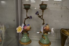 A pair of decorative candlesticks modelled as birds on a branch.
