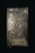 An engraved silver card case.