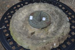 A brass sundial on a reconstituted stone plaque.