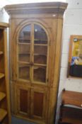 A 19th century pine barrel back corner cupboard bookcase in two parts.