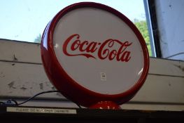 An illuminated double sided sign Coca Cola.