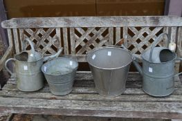 Two galvanized watering cans and two galvanized buckets.