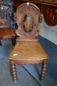 A Victorian oak hall chair.
