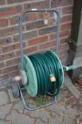 A garden hose on a wheeled trolley.