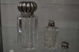 A large cut glass silver mounted perfume bottle and another perfume bottle.