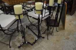 Two pairs of wrought iron candle stands.