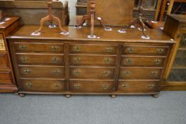 An oak dresser or sideboard with three groups of four drawers.