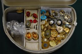 Jewellery box containing numerous pairs of earrings and ear studs.