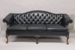 A GOOD LARGE BLUE STUDDED LEATHER SETTEE on claw and ball feet. 6ft 8ins long.