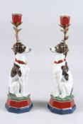 A PAIR OF SEVRES DESIGN PORCELAIN DOG CANDLESTICKS. 14ins high.