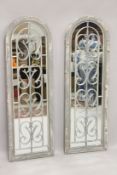 A PAIR OF GREY GARDEN ARCHED MIRRORS. 4ft high.