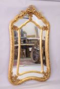 A LARGE DECORATIVE GILT FRAMED SECTIONAL MIRROR, with ribbon and bow cresting. 6ft 6ins high x 3ft