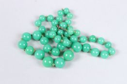 A GREEN JADE BEAD NECKLACE. 20ins long.