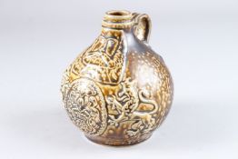 A BELLARMINE TYPE JUG with masks and dragons. 7.5ins high.
