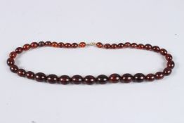 AN AMBER BEAD NECKLACE. 24ins long.
