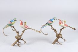 A PAIR OF PORCELAIN AND GILT METAL BIRDS WITH NESTS CANDLESTICKS. 9.5ins high.