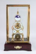 A REPRODUCTION BRASS AND ENAMEL SKELETON CLOCK, with moonphase movement, housed in a display case.