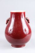 A CHINESE SANG DE BOEUF VASE, of bulbous form with deer head handles. 12ins high.