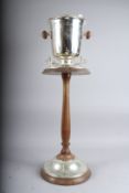 A SILVER PLATED COOLER on a wooden stand. 32ins high.