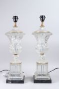 A PAIR OF GLASS URN SHAPED TABLE LAMPS, on square marble bases. 23ins high.