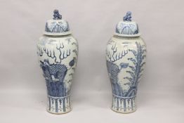 A VERY LARGE PAIR OF CHINESE BLUE AND WHITE VASES AND COVERS. 3ft 6ins high.