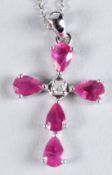 A 9CT WHITE GOLD PEAR-SHAPED RUBY AND DIAMOND CROSS on a silver chain, boxed. Rubies 2.45ct