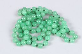 A LONG STRING OF JADE BEADS. 40ins long.