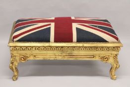 A LARGE GILT UNION JACK STOOL on a gilt base. 3ft 4ins long x 2ft wide.