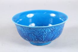 A CHINESE BLUE CIRCULAR BOWL decorated with dragons, with six-character mark. 6ins diameter.