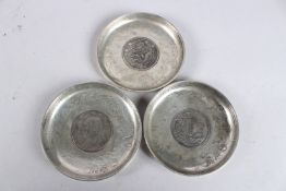 THREE CHINESE WHITE METAL COIN DISHES. 3.5ins diameter.