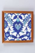 AN IZNIK OR IZNIK STYLE GLAZED POTTERY TILE. 9.5ins square, framed.