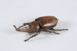 A JAPANESE OKIMONO BRONZE RHINOCEROS BEETLE with articulated wing.