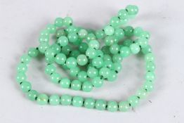A LONG STRING OF JADE BEADS. 40ins long.