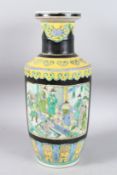 A CHINESE YELLOW GROUND PORCELAIN VASE with panels of figures. 17ins high.