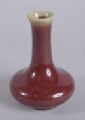 A CHINESE OX BLOOD GLAZE PORCELAIN BOTTLE VASE, 14cms high.