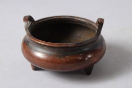 A CHINESE CIRCULAR BRONZE TWO HANDLED CENSER. Imperial mark. 4ins diameter.