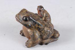 A CHINESE POTTERY GROUP OF TWO FROGS. 3.5ins high.