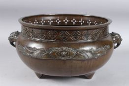 A GOOD LARGE CHINESE BRONZE CIRCULAR JARDINIERE with a pierced rim and elephant handles. 11ins