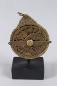 A RARE 19TH CENTURY PERSIAN QAJAR BRASS MINIATURE ASTROLABE. 2ins diameter.