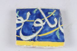A 17TH - 18TH CENTURY PERSIAN SAFAVID CUERDA SECA CALLIGRAPHIC TILE. 6.25ins x 6.75ins