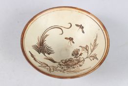 A CHINESE JIZHOU CIRCULAR BOWL with flowers and motifs. 3.75ins diameter.