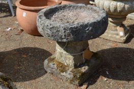 A small composite stone bird bath.